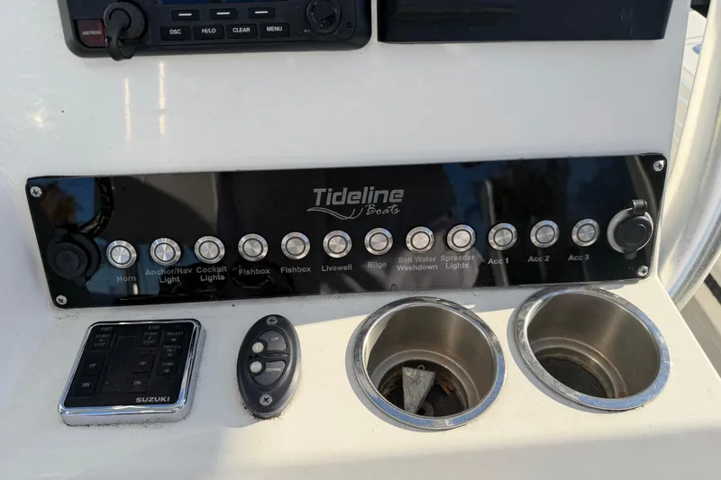 Slide: The Image of Control panel of 2020 Tideline 235 Hybrid boat with various switches and cup holders. - 52