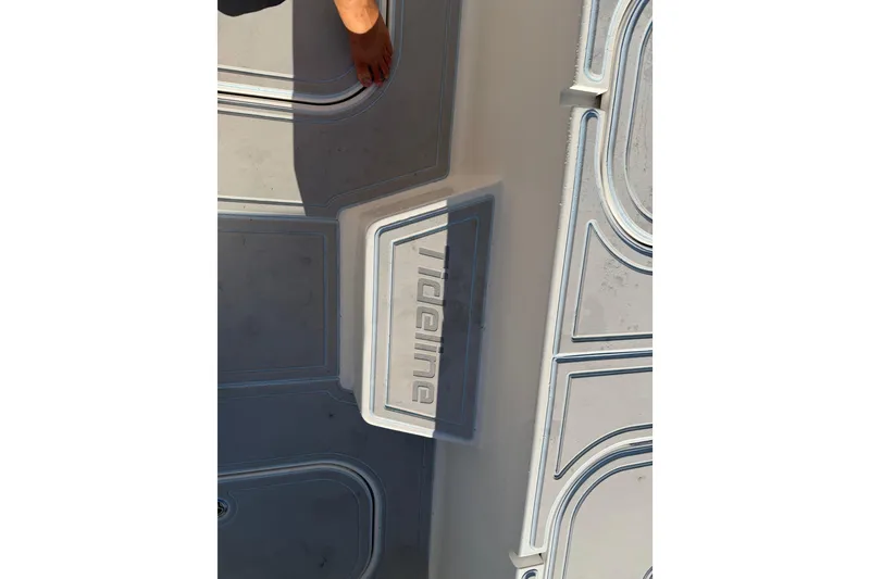 Slide: The Image of 2020 Tideline 235 Hybrid boat deck with embossed logo and hand visible. - 60