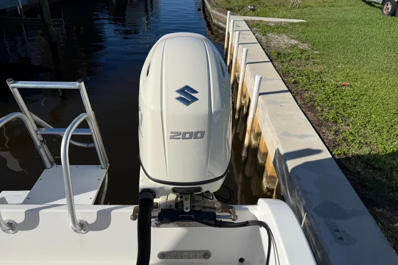 Slide: The Image of Outboard motor on a 2020 Tideline 235 Hybrid boat docked by a canal. - 9