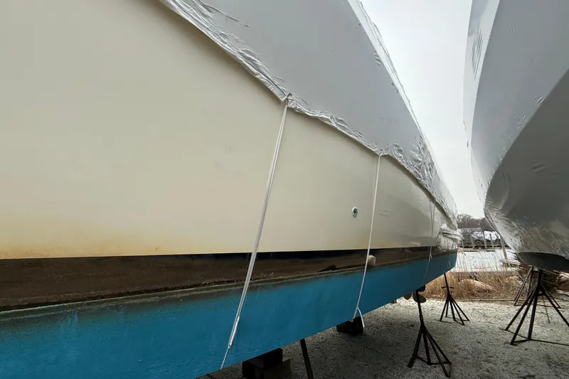 Slide: The Image of 1979 Hatteras 46 Convertible boat wrapped and stored on stands outdoors. - 11