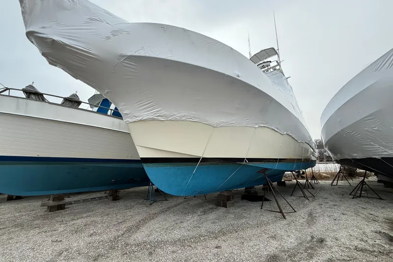 Slide: The Image of 1979 Hatteras 46 Convertible yacht covered in protective wrap, stored on land. - 13