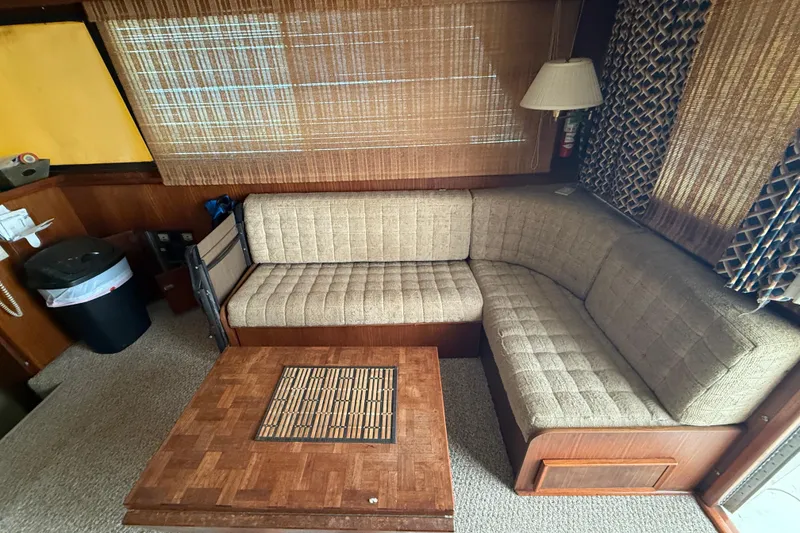Slide: The Image of Interior of 1979 Hatteras 46 Convertible with beige sofa and wooden table. - 16
