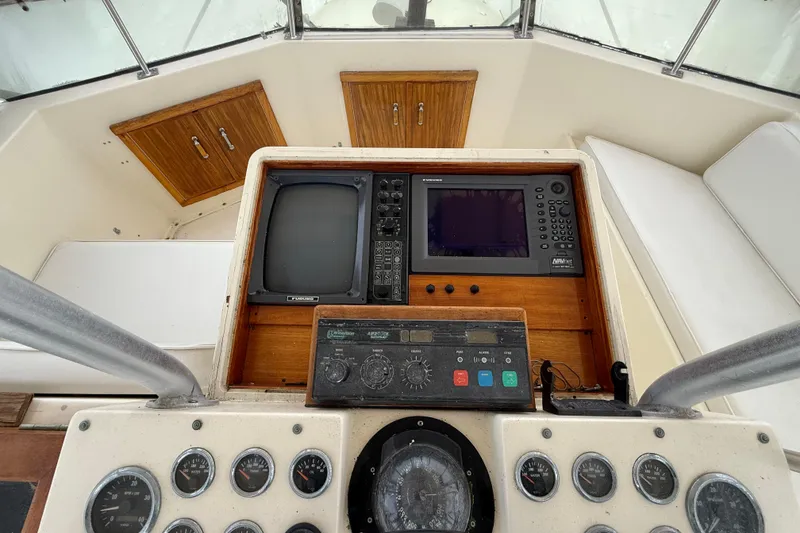 Slide: The Image of 1979 Hatteras 46 Convertible helm with vintage navigation instruments and wooden cabinetry. - 32