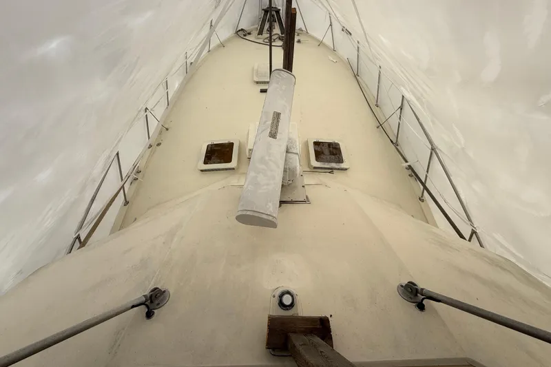 Slide: The Image of 1979 Hatteras 46 Convertible boat deck under protective cover, showcasing hatches and railings. - 37
