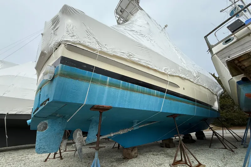 Slide: The Image of 1979 Hatteras 46 Convertible boat, covered and elevated on stands, in a storage yard. - 5