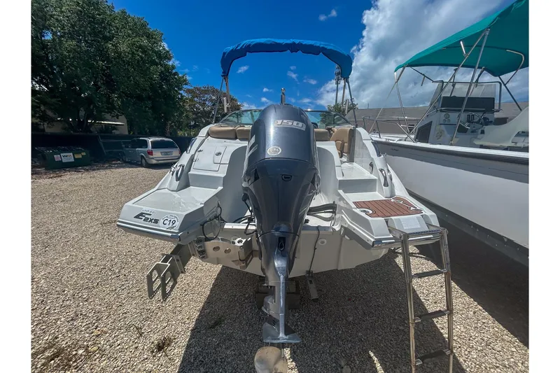 Slide: The Image of 2017 Crownline Eclipse E2 XS boat with outboard motor and blue canopy. - 2