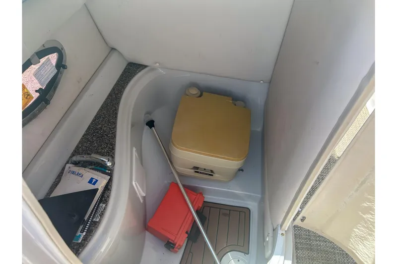 Slide: The Image of 2017 Crownline Eclipse E2 XS boat interior with portable toilet and storage area. - 4