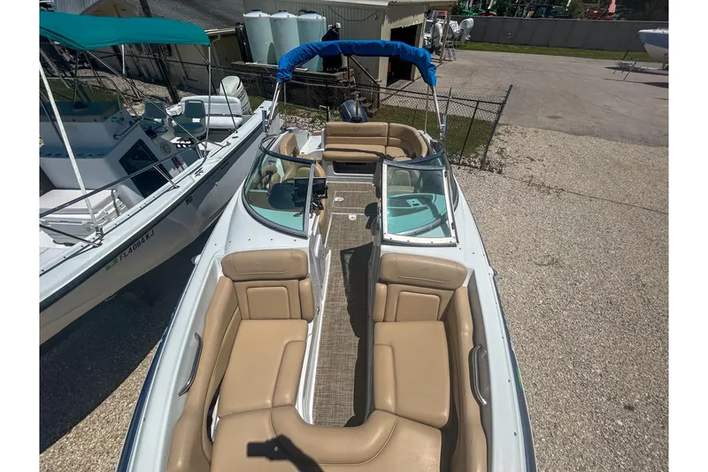 Slide: The Image of 2017 Crownline Eclipse E2 XS boat with tan seating and blue canopy. - 6