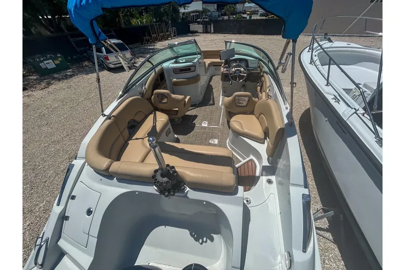 Slide: The Image of 2017 Crownline Eclipse E2 XS boat with tan seating and blue canopy. - 7