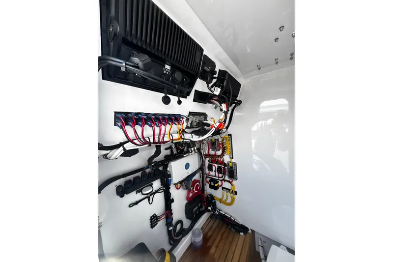 Slide: The Image of Electrical wiring setup inside a 2025 Weaver 25 boat, showcasing organized cables and components. - 11