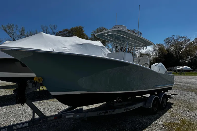 Slide: The Image of 2025 Weaver 25 boat on trailer, parked outdoors under clear blue sky. - 3