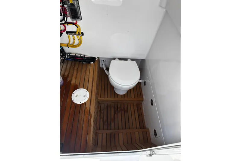 Slide: The Image of Compact marine toilet with wooden flooring in a 2025 Weaver 25 boat. - 8