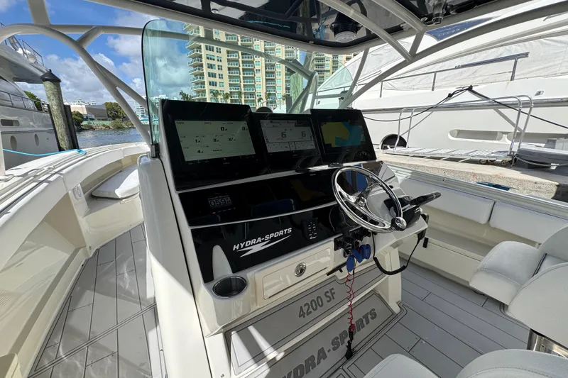 Slide: The Image of 2012 Hydra-Sports 4200 SF boat cockpit with modern navigation equipment and steering wheel. - 8