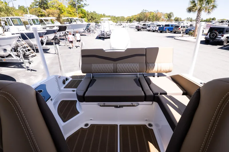 Slide: The Image of 2026 Monterey Elite 25 OB boat interior with luxurious seating at a marina. - 10