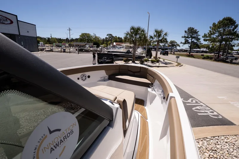 Slide: The Image of 2026 Monterey Elite 25 OB boat with award sticker, docked in sunny marina setting. - 12