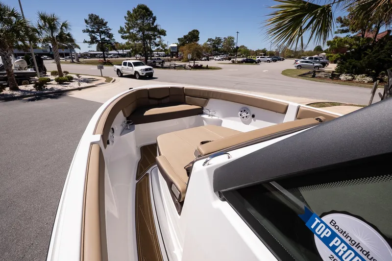 Slide: The Image of 2026 Monterey Elite 25 OB boat with tan seating, parked outdoors. - 13
