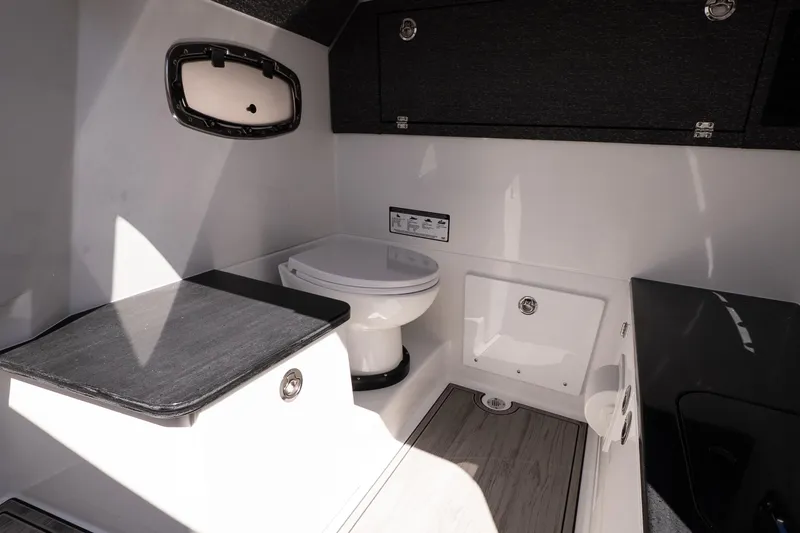 Slide: The Image of Interior of 2026 Monterey Elite 25 OB boat featuring a compact, modern bathroom. - 17