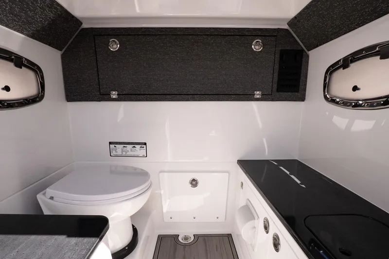 Slide: The Image of Interior of 2026 Monterey Elite 25 OB boat featuring a compact bathroom setup. - 18