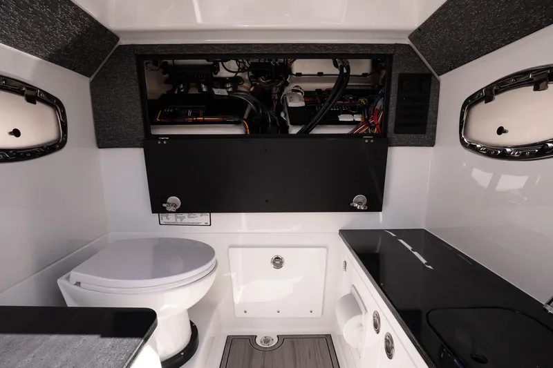 Slide: The Image of Interior of 2026 Monterey Elite 25 OB boat featuring a compact bathroom and storage area. - 19