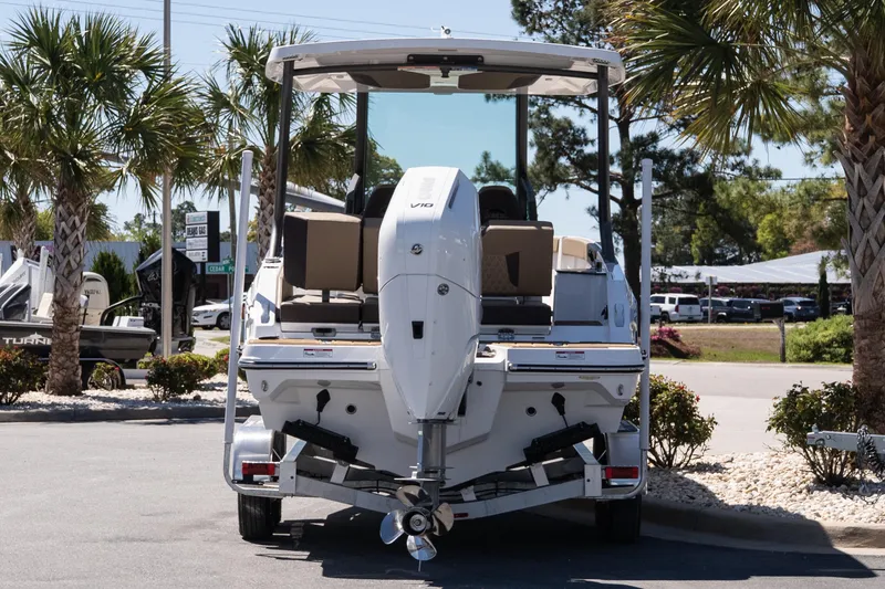 Slide: The Image of 2026 Monterey Elite 25 OB boat on trailer, parked outdoors with palm trees. - 5
