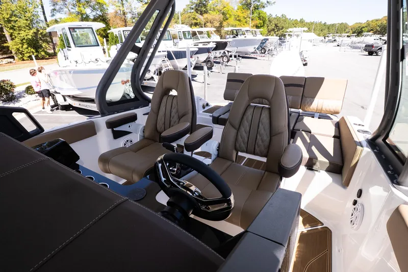 Slide: The Image of Interior of 2026 Monterey Elite 25 OB boat with luxurious seating and modern steering wheel. - 9