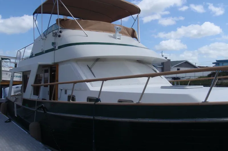 Slide: The Image of 1985 Ocean Alexander yacht docked under a clear blue sky with fluffy clouds. - 81