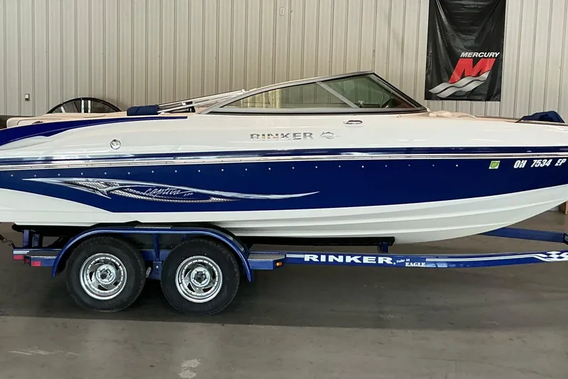 Slide: The Image of 2008 Rinker 226 Captiva Bowrider on trailer, blue and white design, indoor display. - 2