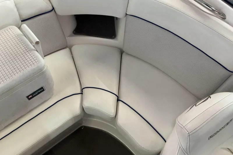 Slide: The Image of 2008 Rinker 226 Captiva Bowrider interior with white cushioned seating and blue accents. - 26