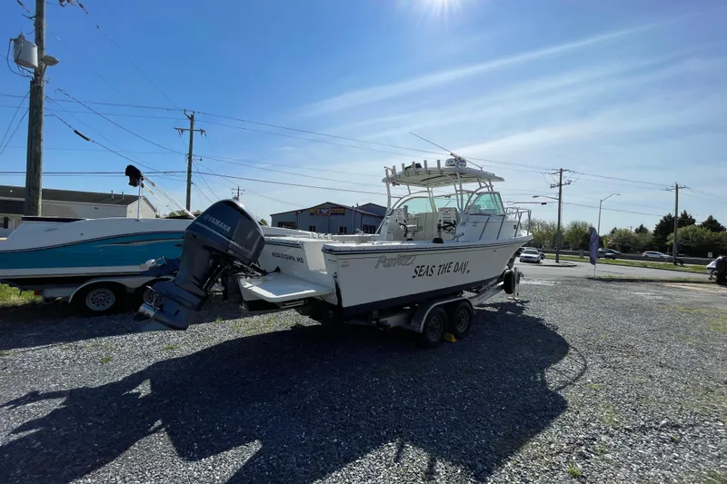 Slide: The Image of 2016 Parker 2510 XL Walkaround boat on trailer, parked outdoors under clear sky. - 10