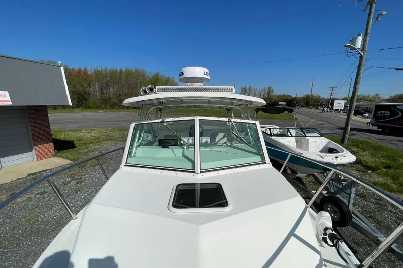 Slide: The Image of 2016 Parker 2510 XL Walkaround boat with radar, docked outdoors under clear blue sky. - 2