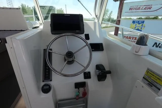 Slide: The Image of 2016 Parker 2510 XL Walkaround boat helm with steering wheel and navigation display. - 7