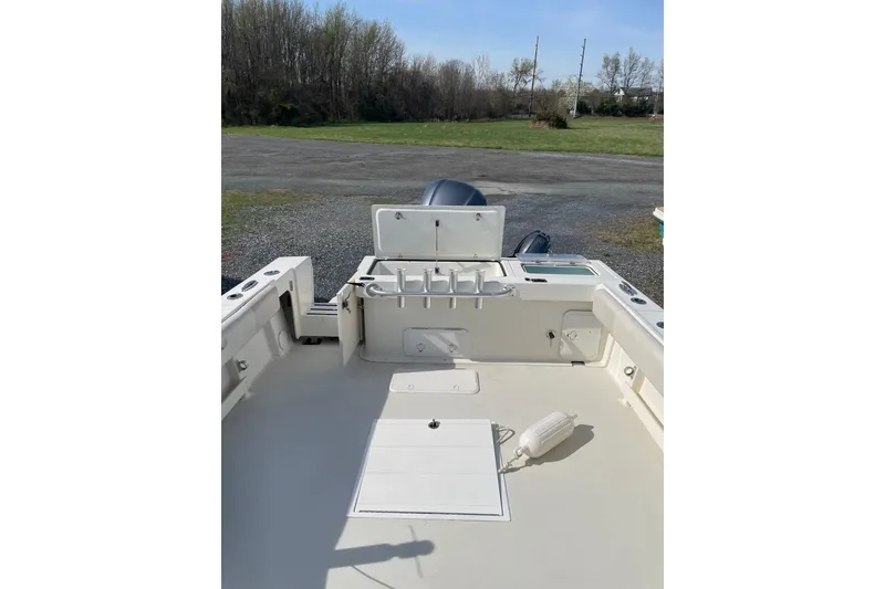 Slide: The Image of 2016 Parker 2510 XL Walkaround boat deck with fishing rod holders and storage compartments. - 8