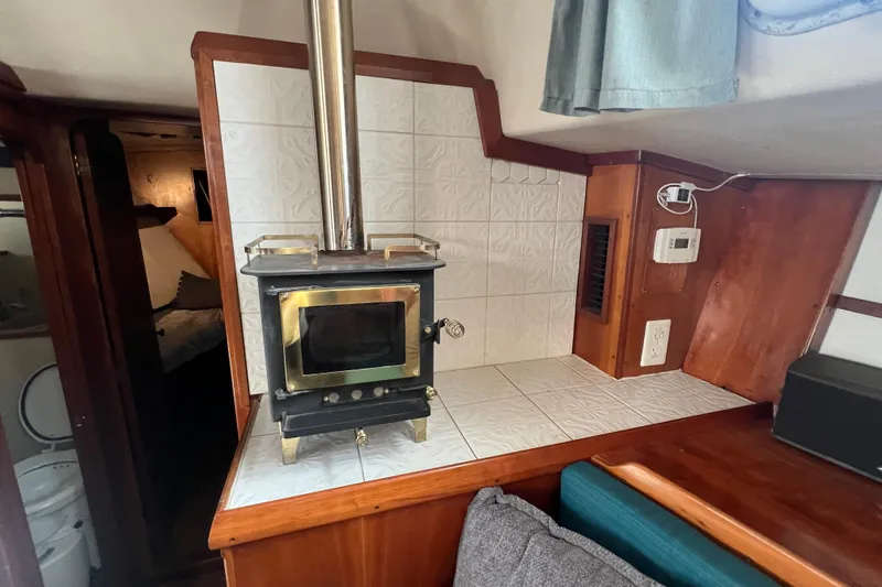 Slide: The Image of Cozy cabin interior of 1983 Durbeck 50 with wood stove and tiled backsplash. - 11