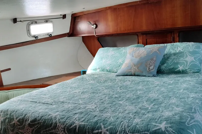 Slide: The Image of Cozy cabin interior of 1983 Durbeck 50 yacht with nautical-themed bedding. - 16