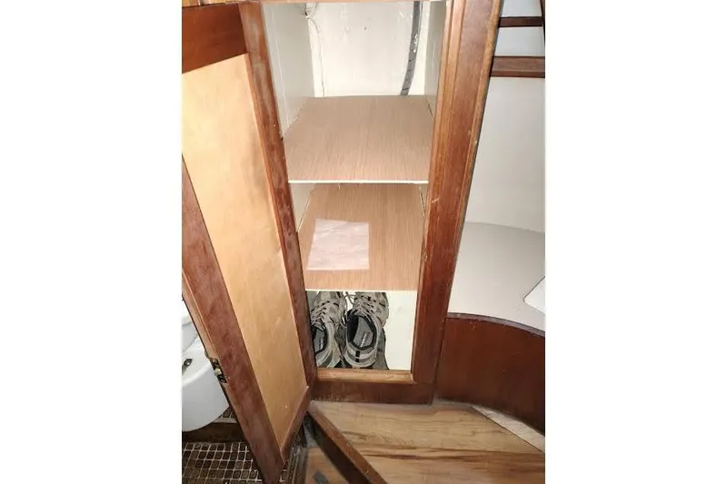Slide: The Image of Wooden cabinet interior with shelves and shoes on a 1983 Durbeck 50 boat. - 17