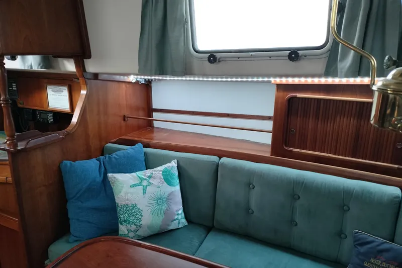 Slide: The Image of Interior of 1983 Durbeck 50 yacht with teal cushions and wooden accents. - 2