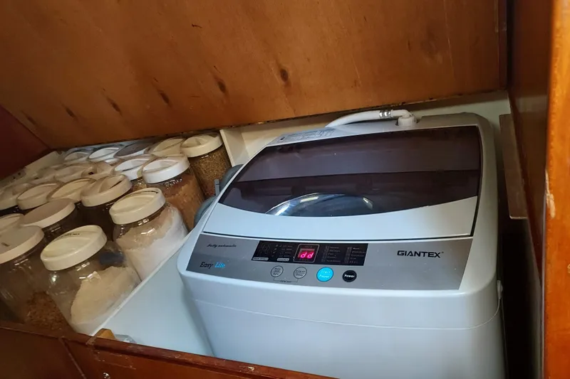 Slide: The Image of Compact washing machine in a wooden cabinet with jars, aboard a 1983 Durbeck 50 sailboat. - 23