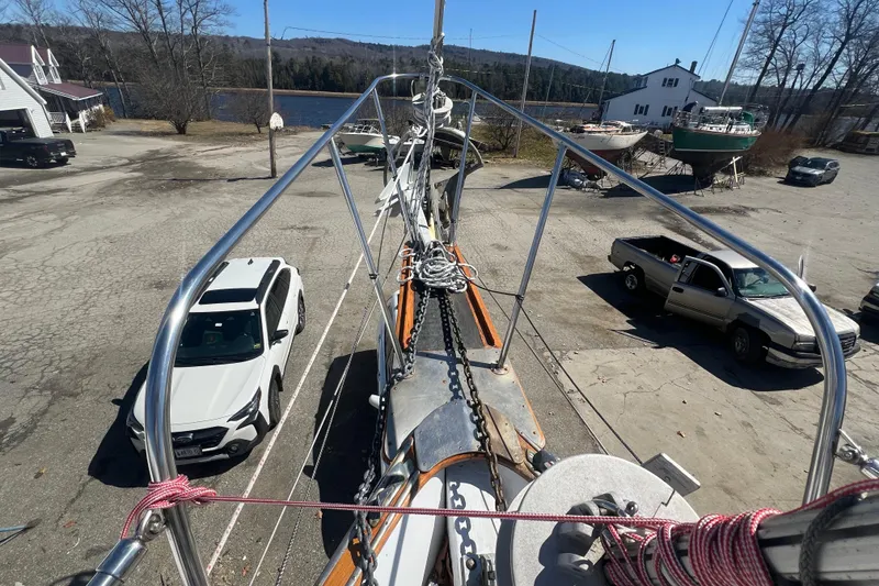 Slide: The Image of View from Durbeck 50 sailboat deck, 1983 model, in a boatyard with parked vehicles. - 25