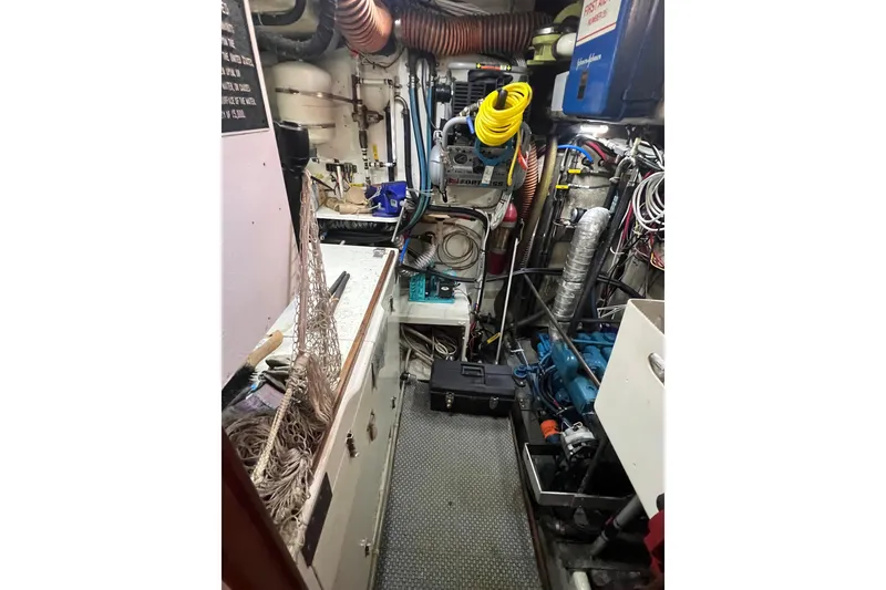 Slide: The Image of Engine room of a 1983 Durbeck 50 boat, featuring various mechanical components and tools. - 28