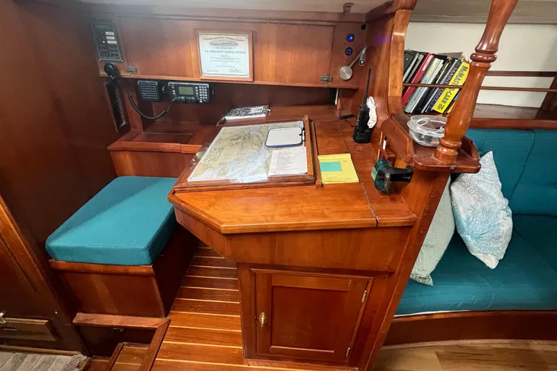 Slide: The Image of Navigation station inside a 1983 Durbeck 50 sailboat with charts and communication equipment. - 3