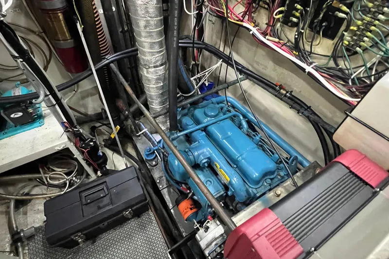 Slide: The Image of Engine room of a 1983 Durbeck 50 boat, featuring a blue engine and wiring. - 32