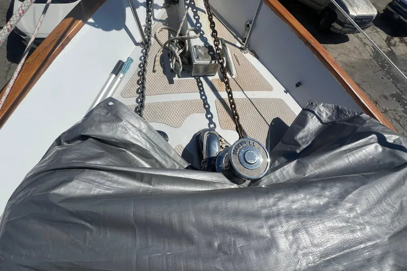 Slide: The Image of Bow of 1983 Durbeck 50 sailboat with anchor chain and winch, partially covered. - 37