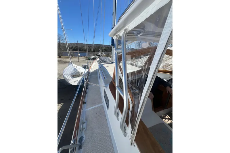 Slide: The Image of 1983 Durbeck 50 sailboat deck view with clear skies and marina background. - 38