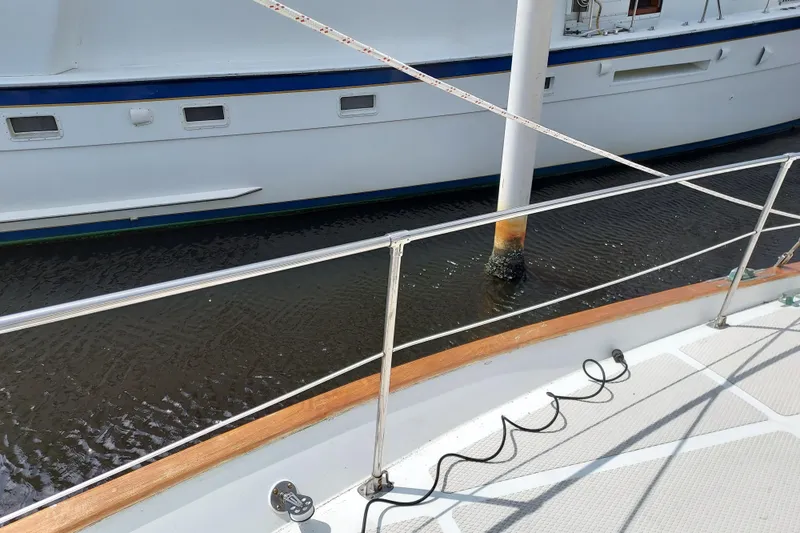 Slide: The Image of 1983 Durbeck 50 yacht deck with railing, docked beside another boat. - 43