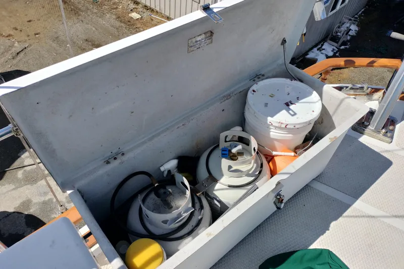 Slide: The Image of Storage compartment on 1983 Durbeck 50 boat with propane tanks and a bucket. - 48