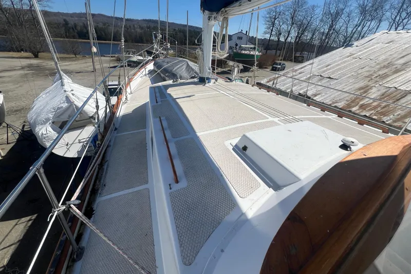 Slide: The Image of 1983 Durbeck 50 sailboat deck with clear sky and waterfront view. - 49