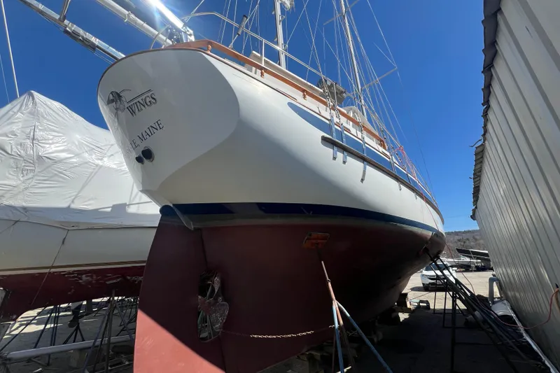 Slide: The Image of 1983 Durbeck 50 sailboat on dry dock, showcasing hull and rigging under clear blue sky. - 51