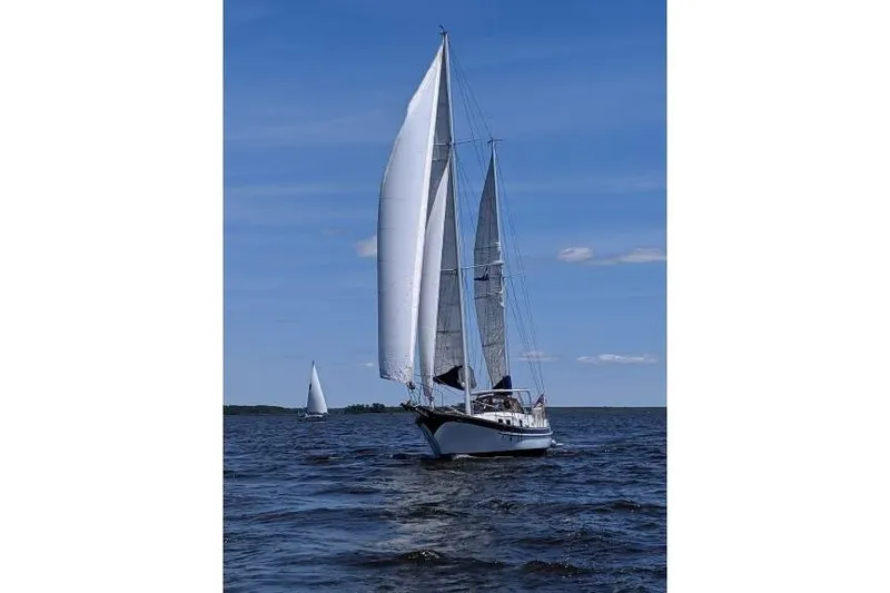 Slide: The Image of Sailing yacht Durbeck 50 from 1983 on open water under clear blue skies. - 55