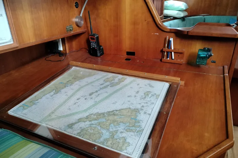 Slide: The Image of Navigation station on 1983 Durbeck 50 sailboat with map, radio, and wooden desk. - 8
