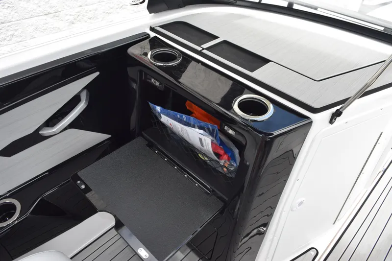 Slide: The Image of 2026 Yamaha Boats 222S interior storage compartment with cup holders and sleek design. - 15